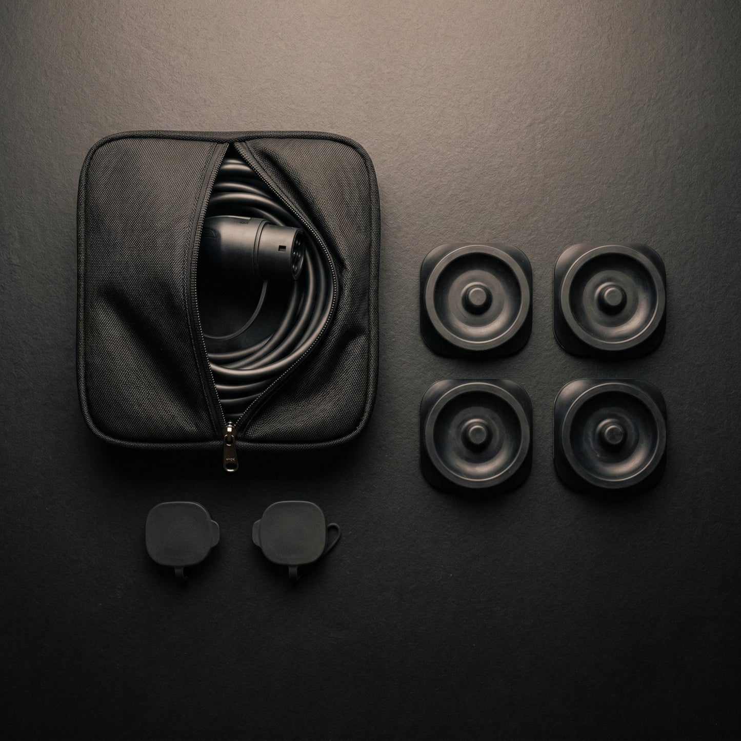 Elevate Automotive EV charging cable bag with cable, two charging port dust caps, and four Tesla jack lift pads.