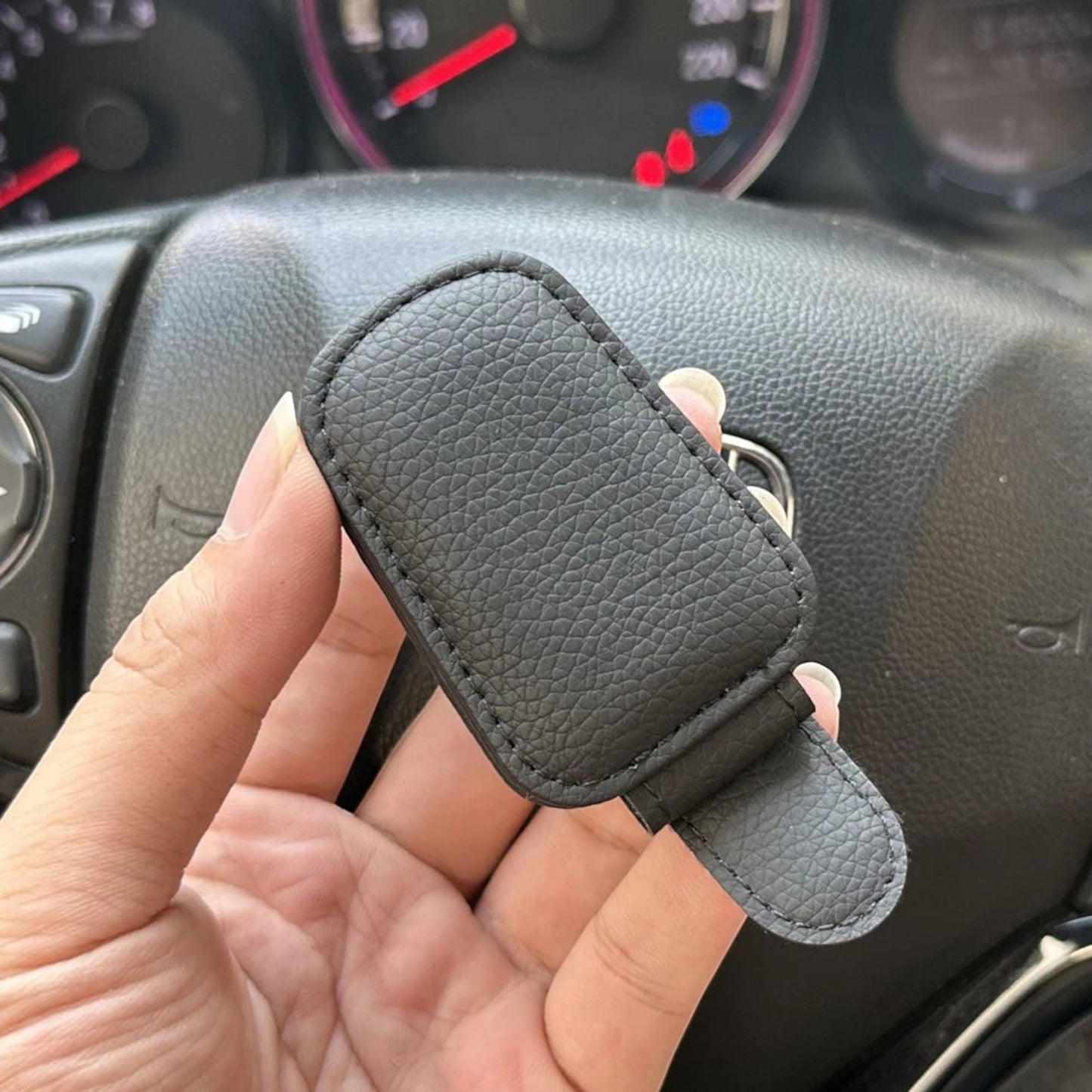 Elevate Automotive black faux leather car sunglasses visor clip with soft lining for scratch-free lens protection.