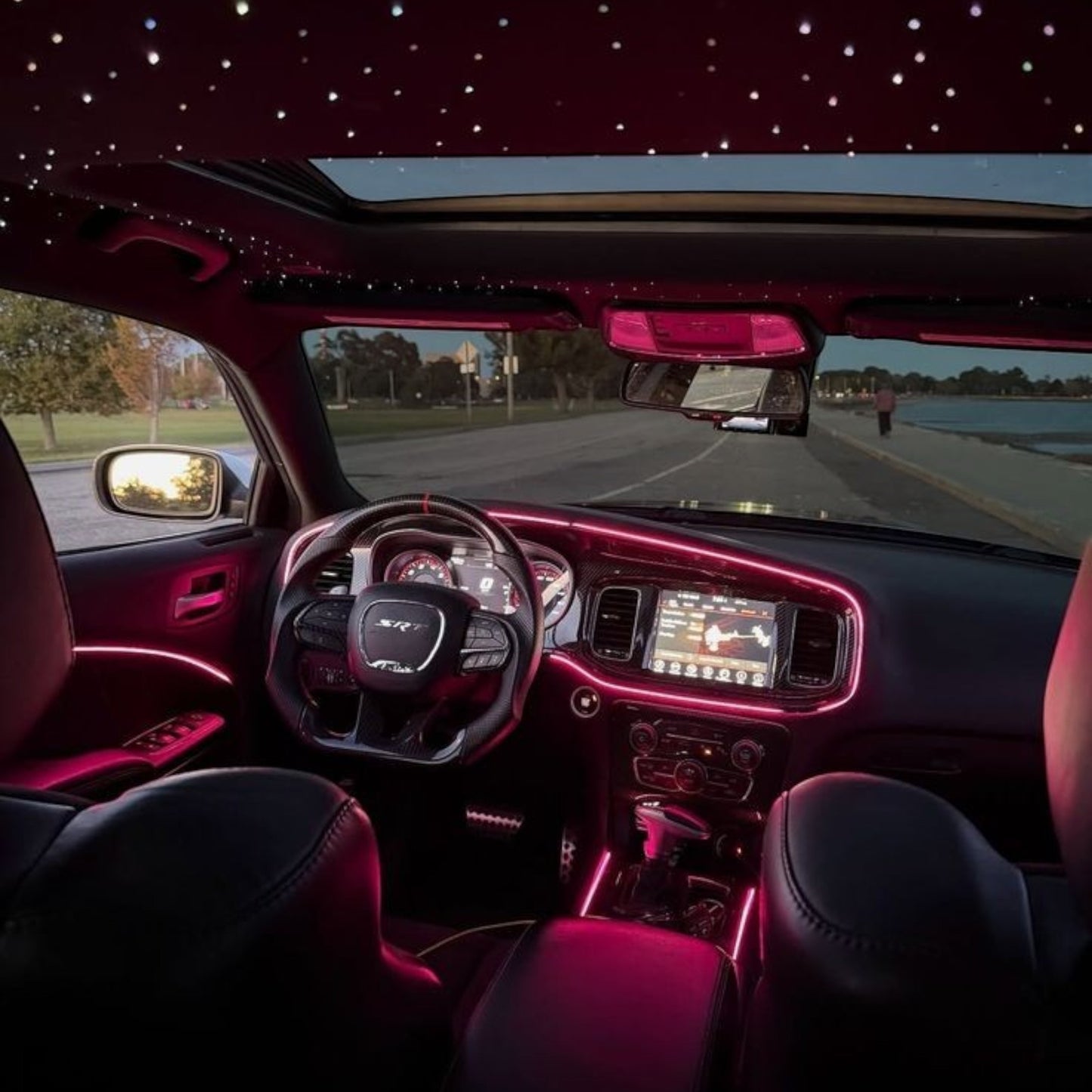 Elevate Automotive car interior with pink ambient lighting and starry night headliner.